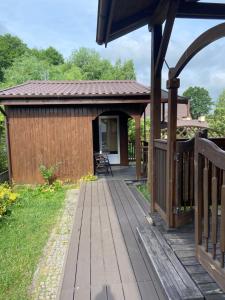 a wooden deck next to a building at Domek wakacyjny in Charzykowy