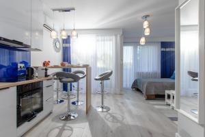 una cocina con 2 taburetes y una habitación con cama en Resort Apartamenty Klifowa Rewal 61, en Rewal