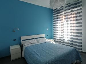 Un dormitorio azul con una cama y una pared azul. en P in centro 2, en Sestri Levante