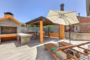 a patio with a table and an umbrella at Apartments Kristijan in Senj