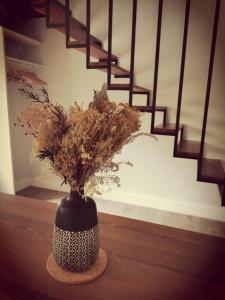 レ・ゼルビエにあるDuplex INDEPENDANT Centre villeの階段の横のテーブルに置かれた白黒の花瓶