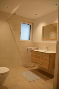 uma casa de banho com um lavatório, um WC e um espelho. em Apart Bergsonne em Fiss