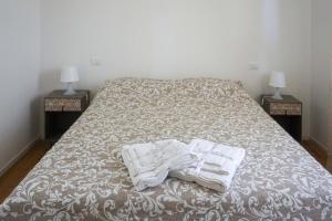a bed with towels on it with two night stands at La Veranda Bed and Breakfast in Ravenna