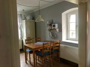 uma cozinha com uma mesa e cadeiras de madeira e uma janela em Ferienwohnung alter Bauernhof em Dresden