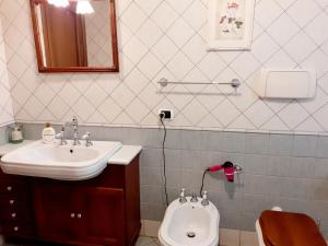 uma casa de banho com um lavatório e um WC em A casa di Sabina, appartamento a Castelbuono em Castelbuono