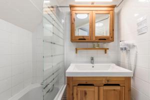 a bathroom with a sink and a mirror and a tub at Hotel Le Clos Fleuri in Le Palais