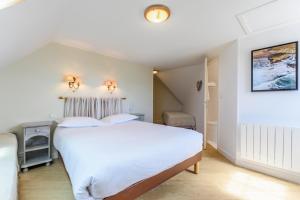 a bedroom with a large white bed in a room at Hotel Le Clos Fleuri in Le Palais