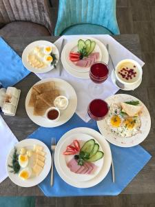 stół z talerzami śniadaniowymi. w obiekcie Hotel Nikola w mieście Listwianka