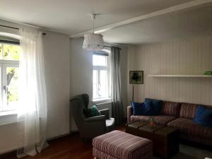 uma sala de estar com um sofá e uma cadeira em Ferienwohnung alter Bauernhof em Dresden