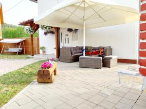 a patio with an umbrella and couches at Kuća za odmor Marija in Vrhovine