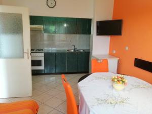 a kitchen with a table and a kitchen with orange walls at Apartments Branka in Ika