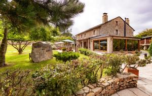 a house with a garden and a stone wall at Casa do Mudo in Cervo