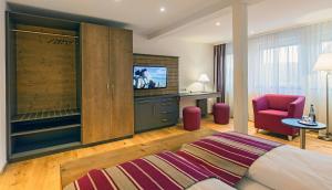 a hotel room with a bed and a tv and a chair at Hotel Waldeck in Feldberg