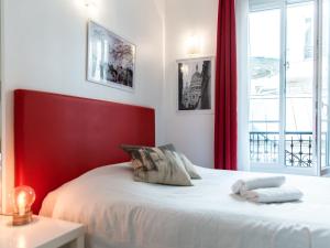 a bedroom with a red and white bed and a window at Montmartre Apartments Dalida in Paris