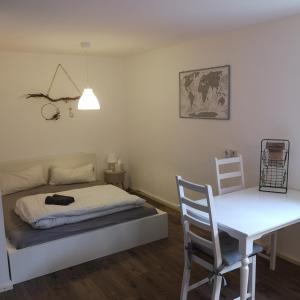 1 dormitorio con cama, mesa y escritorio en Gemütliche Wohnung in Wolfegg - Das Tor zum Allgäu en Wolfegg