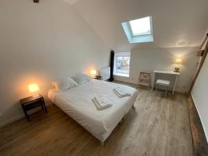 a bedroom with a white bed and a window at La MAIS'ANGE - Charmante maison proche centre in Blois