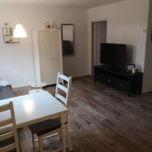 sala de estar con mesa y TV en Gemütliche Wohnung in Wolfegg - Das Tor zum Allgäu en Wolfegg