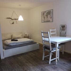 1 dormitorio con cama, escritorio y mesa en Gemütliche Wohnung in Wolfegg - Das Tor zum Allgäu en Wolfegg
