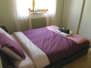 uma cama com um bicho de peluche em cima em La Conciergerie du Manoir em Saint-Léger-sur-Dheune