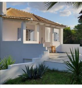 a white house with stairs in front of it at Olive Grove Soulis Family Estate in Porto Heli