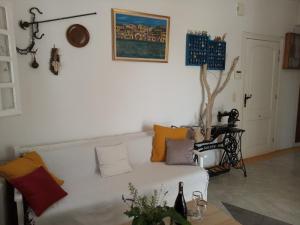 Olive Grove Soulis Family Estate في بورتوخيلي: غرفة معيشة مع أريكة بيضاء مع وسائد ملونة