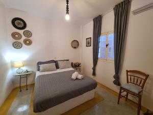 a bedroom with a bed and a chair and a window at Olive Grove Soulis Family Estate in Porto Heli