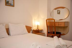 ソゾポルにあるConvenient 2-Bedroom Flat next to Harmanite Beach by Flаt Mаnagerのベッドルーム1室(ベッド1台、鏡、椅子付)