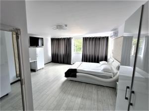 a white bedroom with a bed and a window at Cazare Casa Noastra in Viforîta