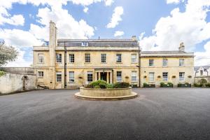 a large stone building with a clock on the front of it at Best Western Leigh Park Hotel in Bradford on Avon