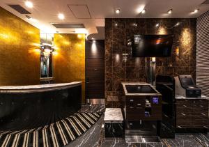 福岡市にあるアパホテル〈博多駅筑紫口〉のバスルーム(洗面台付)、壁掛けテレビが備わります。