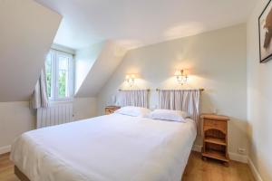 a bedroom with a large white bed and two windows at Hotel Le Clos Fleuri in Le Palais
