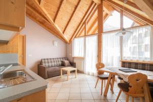 a kitchen and living room with a wooden ceiling at Apartments Ansciuda in Ortisei +26 photos