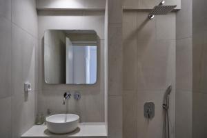 a bathroom with a sink and a mirror and a shower at Cleopatra Seaside Homes, Logaras, Paros in Piso Livadi