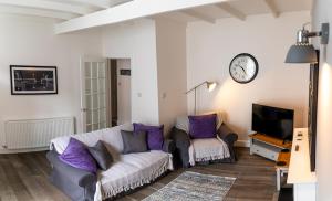 a living room with a couch and a tv at The Old Paint Shop Apartment - Centrally Situated in Anstruther