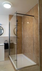 a shower with a glass door in a bathroom at The Old Paint Shop Apartment - Centrally Situated in Anstruther