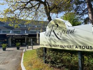 una señal para un hotel frente a un edificio en Le Regina Hôtel restaurant en Hardelot-Plage