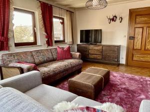 een woonkamer met een bank en een tv bij Ferienwohnungen im Eugenhaus in Rosenfeld