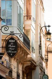 un panneau indiquant un hôtel situé sur le côté d'un bâtiment dans l'établissement Le Relais Saint Honoré, à Paris