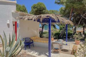 a pergola with a bench and chairs in a yard at Quinta la Sal in Jávea