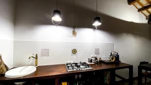 a kitchen with a counter and a stove and lights at Arte Povera Landhaus in idyllischem Naturreservat in Custonaci