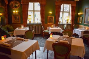 a dining room with tables and chairs and windows at Hotel Dagmar in Ribe