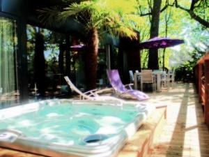 a hot tub with two chairs and an umbrella at Oasis in Arcachon