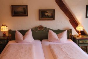 a bedroom with two beds with pillows on them at Hotel Spitzweg in Rothenburg ob der Tauber