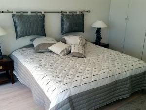a large bed with pillows on it in a bedroom at Appartement Panoramic in Arcachon