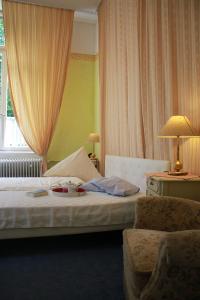 ダルムシュタットにあるHotel Waldfriedeのベッドと椅子付きのホテルルーム