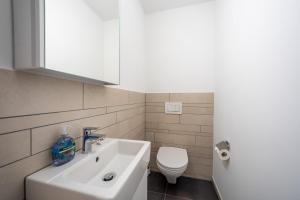 a bathroom with a white sink and a toilet at Vallada 14 01 in Flims