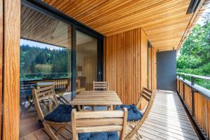 a wooden table and chairs on the balcony of a house at Vallada 14 01 in Flims