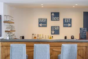 un bar avec des chaises bleues devant lui dans l'établissement Hotel Le Clos Fleuri, au Palais