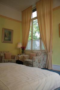 ein Schlafzimmer mit einem Bett und einem großen Fenster in der Unterkunft Hotel Waldfriede in Darmstadt