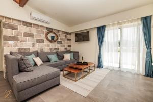 a living room with a couch and a brick wall at Apartments Cukovic in Herceg-Novi